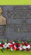 Tablica upamiętniająca Wincentego Witosa ozdobiona biało-czerwonymi kwiatami