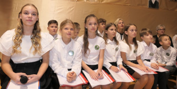 Grupa dzieci siedząca obok siebie