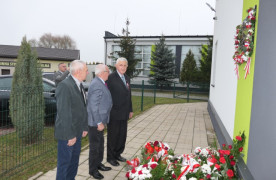 Mężczyźni stoją przed tablicą pamiątkową 