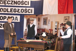 Trzej chłopcy biorący udział w akademii szkolnej 