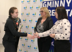 Dwie kobiety i dziewczynka. Kobieta gratuluje dziewczynie 