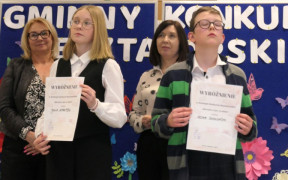 Dwie kobiety, dziewczyna i chłopiec. Dziewczynka i chłopiec trzymają w reku dyplomy