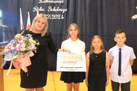 Kobieta i trójka dzieci. Kobieta trzyma w ręku kwiaty