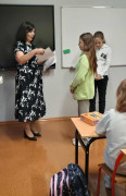 Kobieta wręcza uczniom dyplomy 