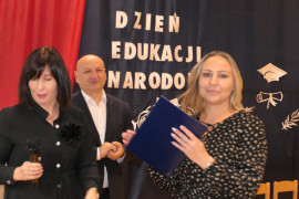 Dwie kobiety i mężczyzna. Moment wręczania gratulacji. 