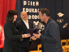 Kobieta i dwaj mężczyźni. Moment wręczania gratulacji