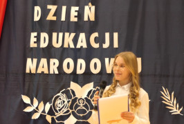 Uczennica trzyma mikrofon w ręku. Uczennica podczas akademii szkolnej 