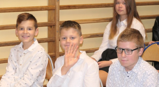 Uczniowie siedzący obok siebie na ławce