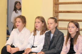 Uczniowie siedzą obok siebie na ławce 