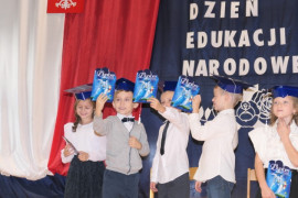 Pierwszoklasiści pokazują symboliczne dyplomy 