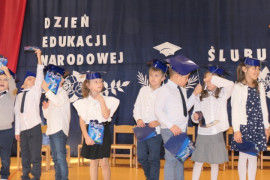 Pierwszoklasiści mają na głowach granatowe birety. W ręku trzymają symboliczne dyplomy 