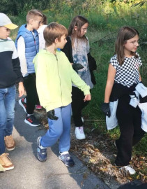 Dzieci i młodzież podczas zbieranie śmieci znalezionych m.in. na terenach zielonych 