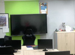 Sala lekcyjna. Widoczny ekran telewizora oraz monitory komputerów