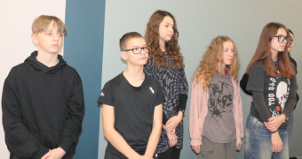 Grupa młodych ludzi stoi obok siebie