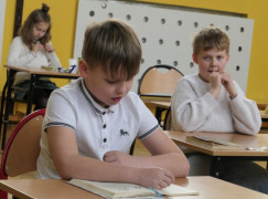 Chłopiec siedzi w ławce i czyta tekst
