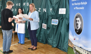 Chłopiec odbiera dyplom z rąk kobiety