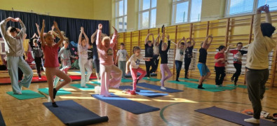 Dzieci podczas zajęć sportowych. Wszystkie podskakują i mają ręce uniesione do góry 