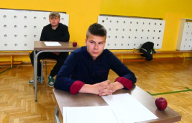 Dwóch chłopców siedzących w ławkach 