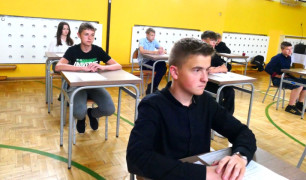 Uczniowie siedzący w ławkach 