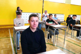 Uczniowie siedzący w ławkach 
