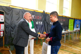 Chłopiec odbiera gratulacje od mężczyzny