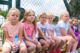 Grupa dzieci siedzących na ławce 