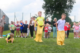 Dzieci skaczące w workach podczas zawodów sportowych 
