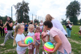 Dzieci odbierają nagrody z rąk dorosłych 