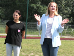 Dwie kobiety stoją obok siebie na murawie boiska 