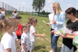 Kobieta wręcza dyplom dziewczynce 