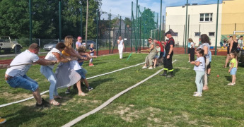 Dzieci i dorośli podczas konkurencji polegającej na przeciąganiu liny