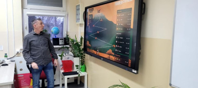 Mężczyzna stoi przy tablicy multimedialnej