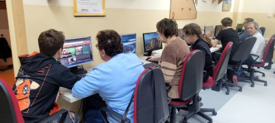 Dorośli i dzieci siedzą przy komputerach