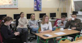 Grupa uczniów siedzi w grupie 