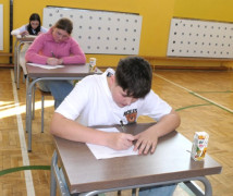 Uczestnicy konkursu pożarniczego. Dzieci siedzą w ławkach i rozwiązują test