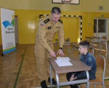 Strażak podaje chłopcu kartkę z pytaniami