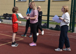 Kobieta wręcza chłopcu dyplom. 