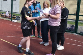 Kobieta wręcza dyplom dziewczynie 