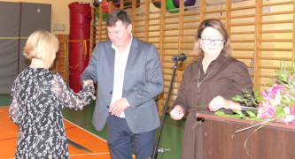 Dwie kobiety i mężczyzna. Mężczyzna gratuluje kobiecie 