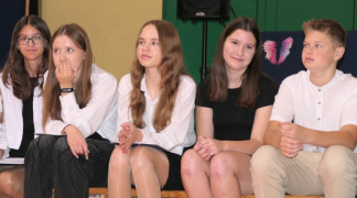Uczniowie siedzą na ławce