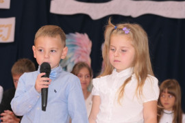 Dziewczynka i chłopiec. Chłopiec trzyma w ręku mikrofon