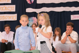 Chłopiec i dziewczynka podczas akademii szkolnej 