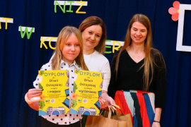 Dwie kobiety i dziewczynka trzymająca w ręku dwa dyplomy 