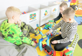 Trzej chłopcy podczas układania klocków lego 