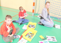 Uczniowie i nauczycielka układają klocki lego