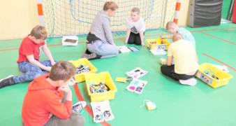 Uczniowie i nauczycielka układają klocki lego