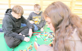 Dziewczyna i dwaj chłopcy układają klocki lego