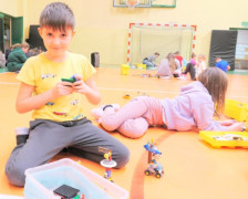 Chłopiec prezentuje zabawkę, którą ułożył z klocków lego