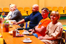 Grupa dorosłych siedząca przy stole 
