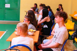 Grupa dzieci siedząca na trybunach 